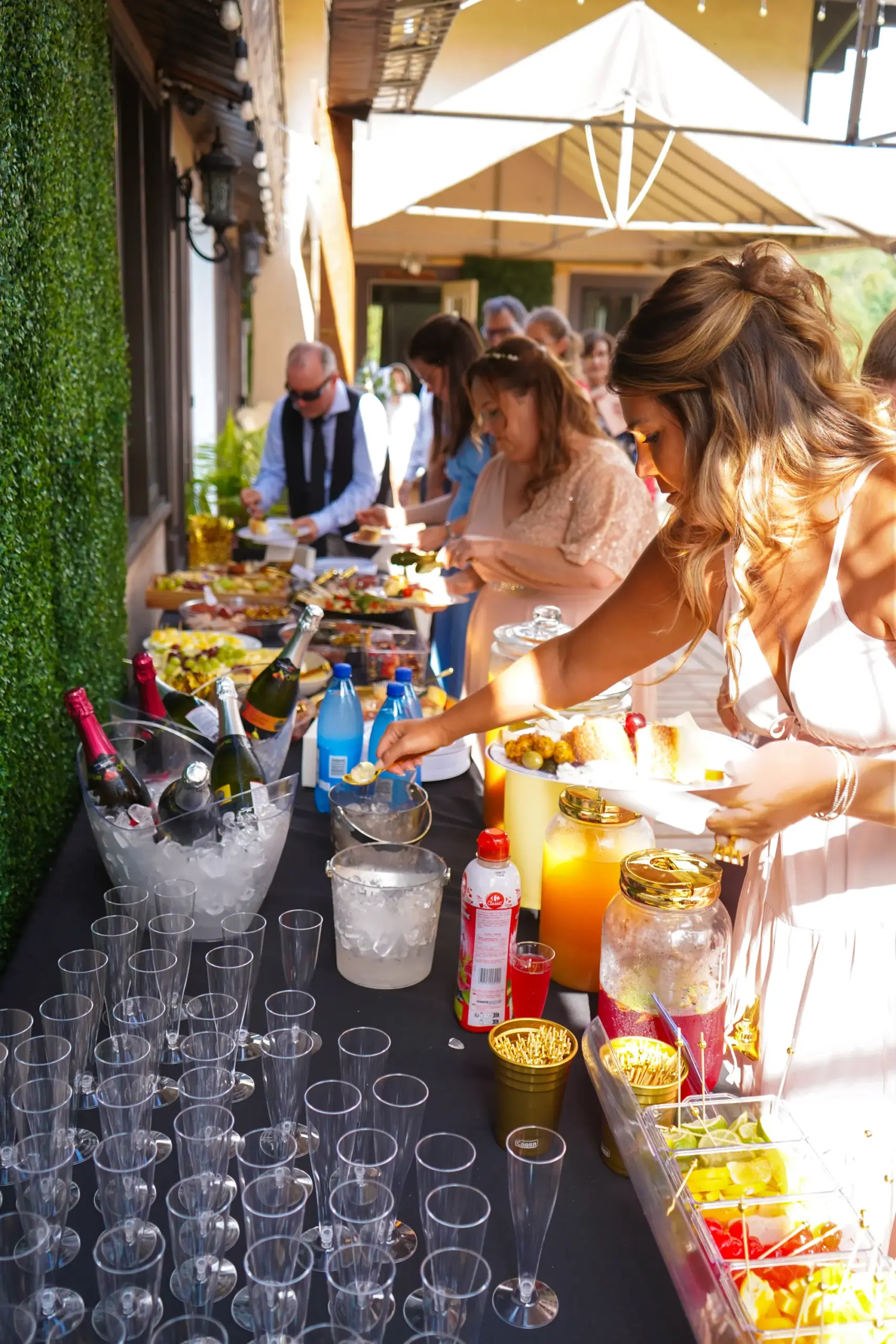 Buffet et bar à mimosas sur la terrasse, invités se servant