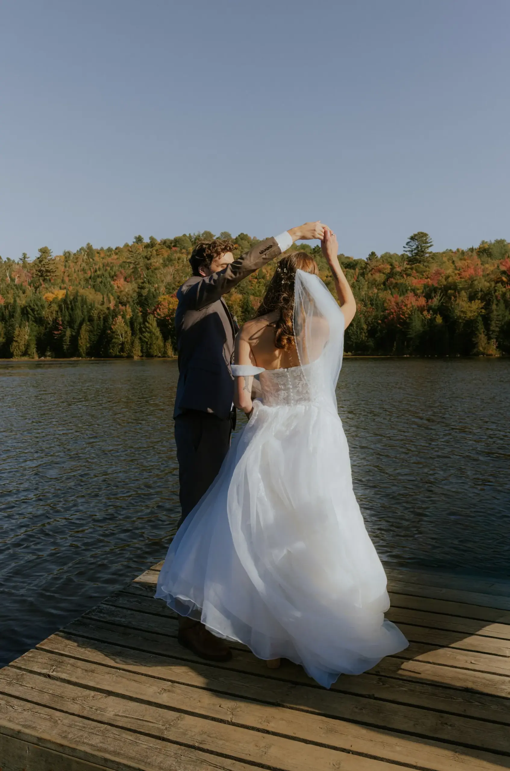 Les mariés dansent sur le quai, forêt aux couleurs d'automne