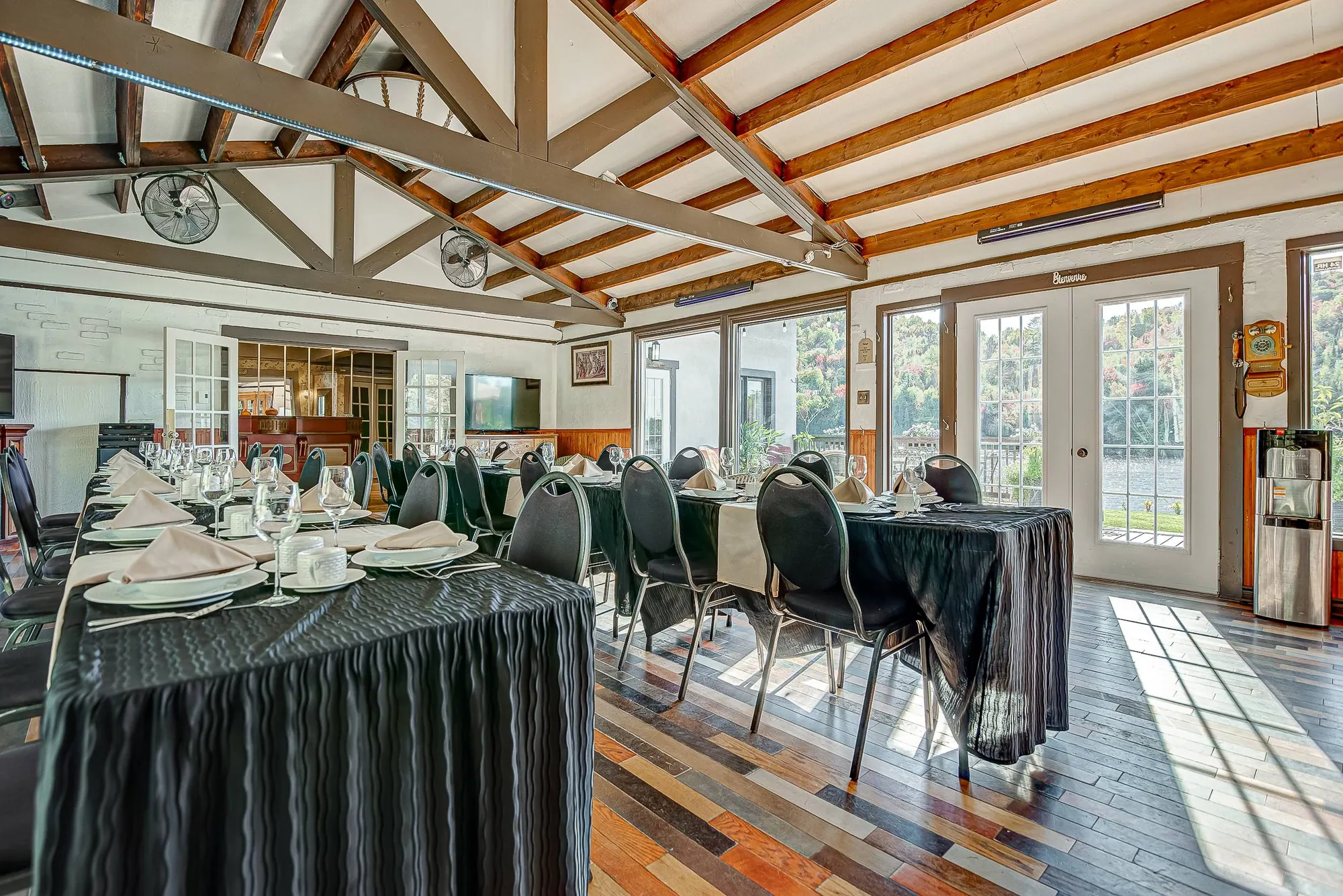 Salle à manger intérieure avec vue sur le lac, tables dressées