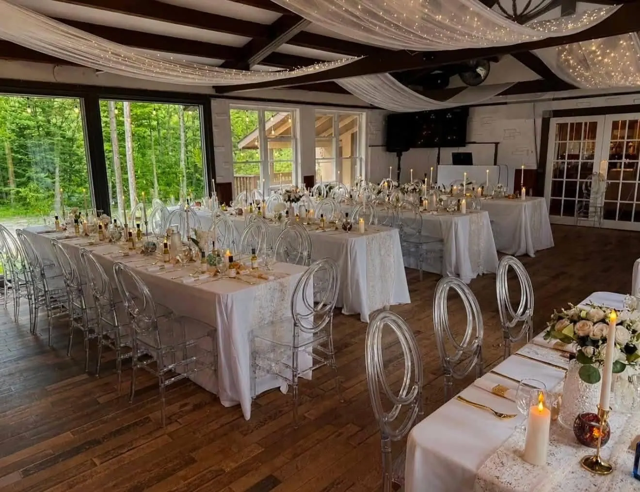 Salle à manger avec voilages lumineux au plafond, chaises transparentes et tables dressées